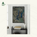 Framed aerial art print of Lake Wanaka on a wall in a room with a shelf and vase.