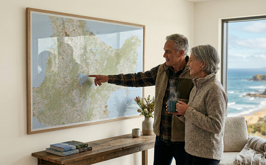Man and woman looking at a map of the central North Island of New Zealand  in a living room with a view of the ocean.