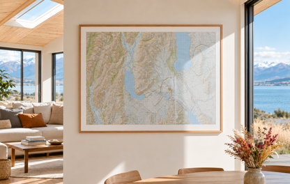 Framed map of Lake Ohau and Twizel on a wall in a room with large windows overlooking a scenic view.