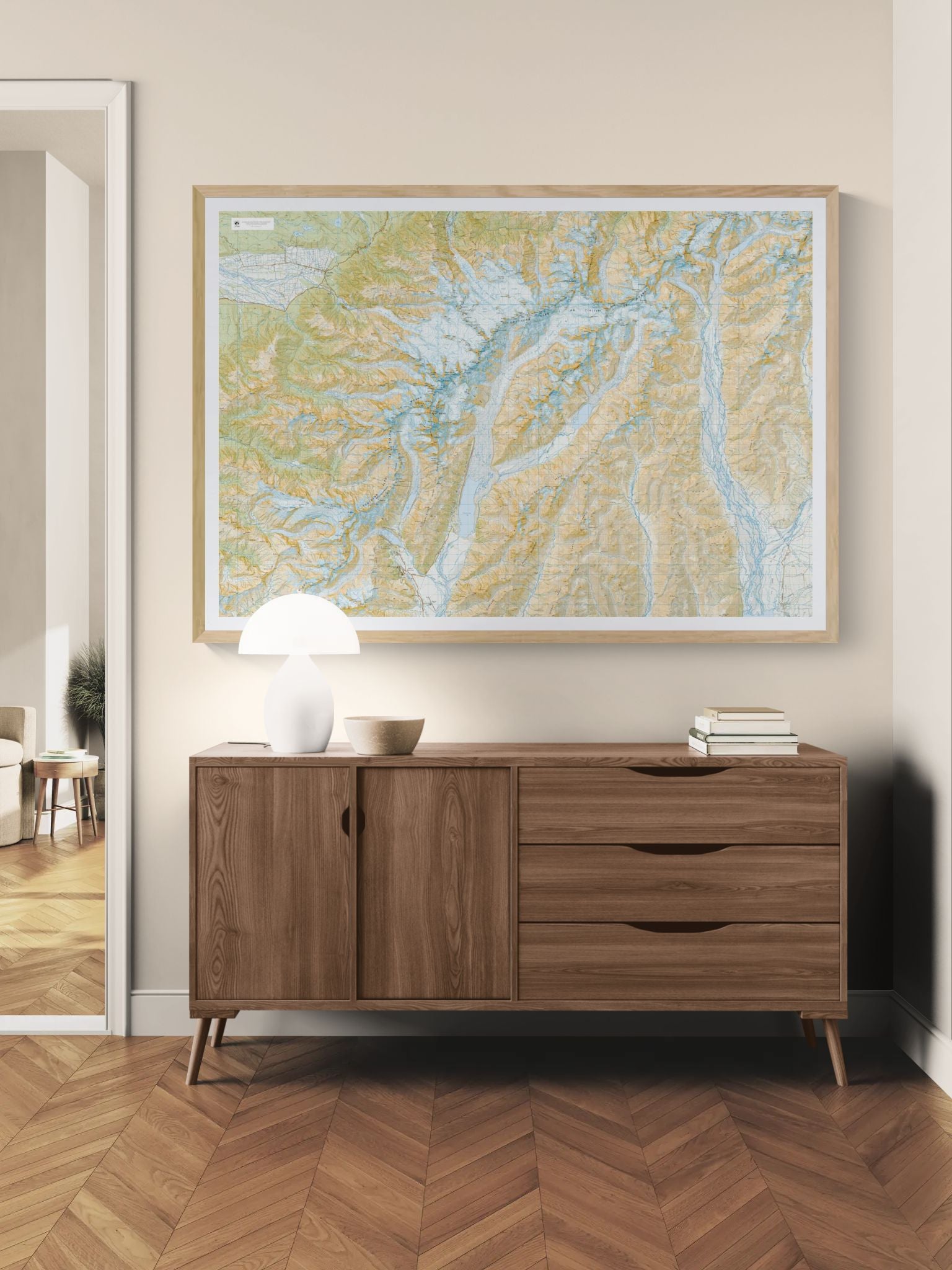 Wooden sideboard with a map on the wall above it in a room with wooden flooring.