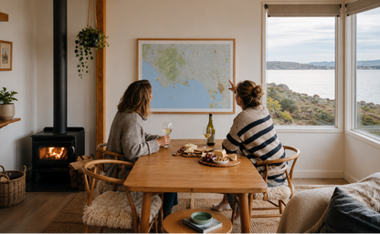 Two people sitting at a table in a room with a large window view, a fireplace, and a large map on the wall of Riverton and the surrounding area