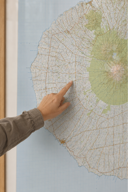 Hand pointing at a map of Taranaki on a wall