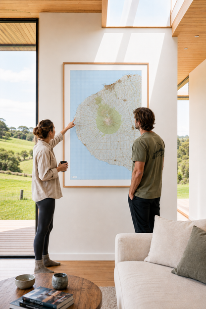 Two people in a modern living room with a large framed picture of a landscape.