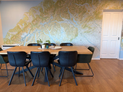 A modern dining room with a large topographical map wall mural.