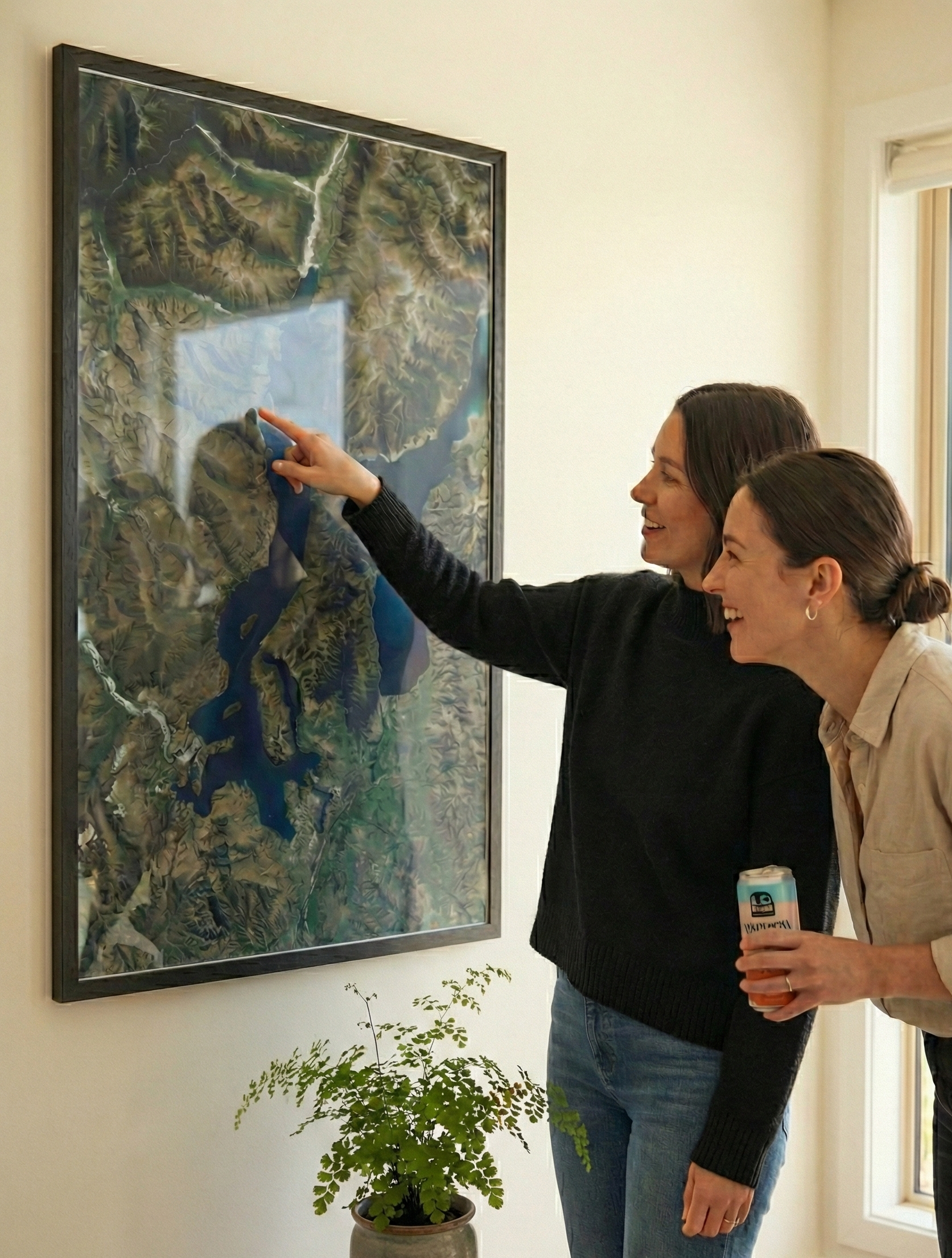 Two women looking at an aerial map of Wanaka on the wall.