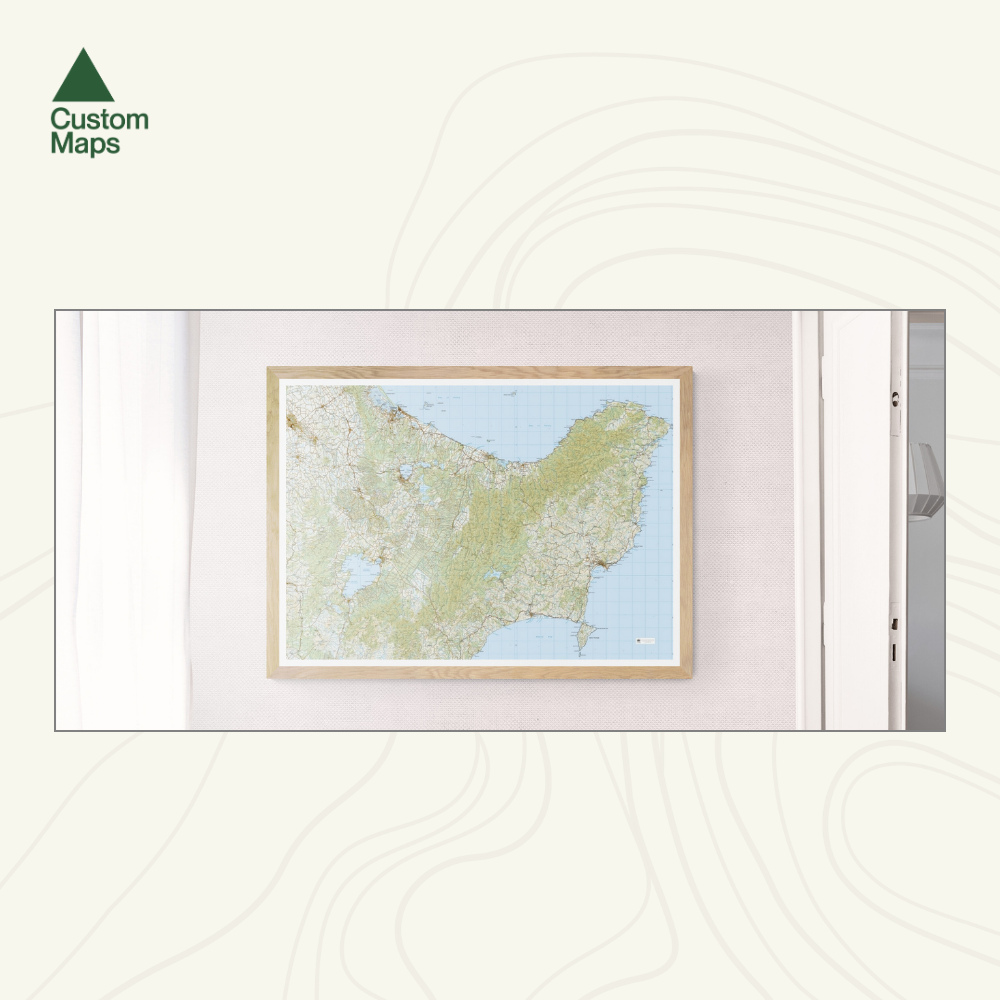 Framed topographic map of the East Cape on a white wall with 'Custom Maps' logo.