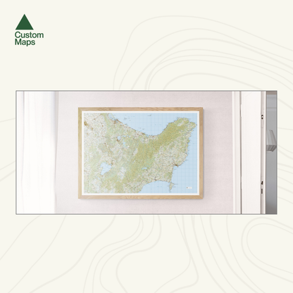 Framed topographic map of the East Cape on a white wall with 'Custom Maps' logo.