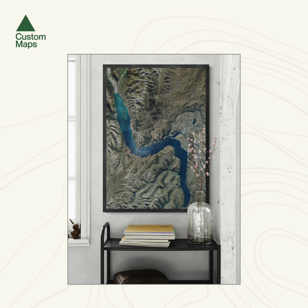 Framed aerial map of Queenstown displayed in a room.