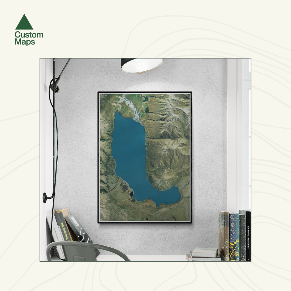 Framed aerial map of a lake on a wall above a desk.