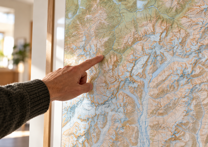 Close-up of a hand pointing to glaciers and ridgelines on the Godley Valley topographic wall map