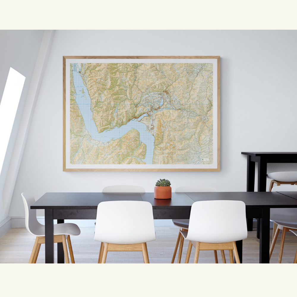 Framed map of Queenstown and Arrowtown on a wall above a dining table with chairs